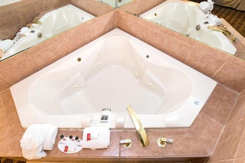 a large bath tub in a bathroom with two sinks at Ramada by Wyndham Plymouth Hotel & Conference Center in Plymouth