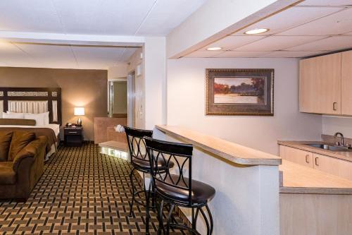 a hotel room with a kitchen and a living room at Ramada by Wyndham Plymouth Hotel & Conference Center in Plymouth