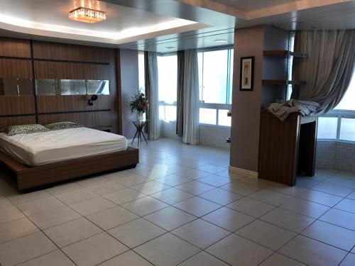 a bedroom with a bed in a room with large windows at Cobertura Beira Mar in Capão da Canoa