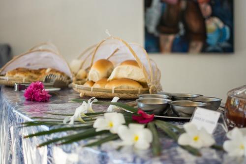 una mesa con cestas de pan y flores. en Pousada Mediterrânea, en Pipa