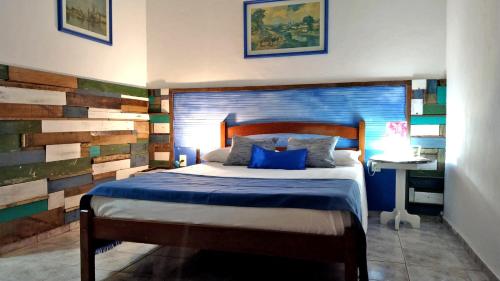 a bedroom with a bed and a wooden accent wall at Pousada Costa Verde in Abraão