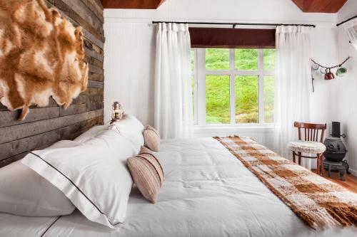 a bedroom with a large bed and a window at Hotel Boutique La Yegua Loca in Punta Arenas