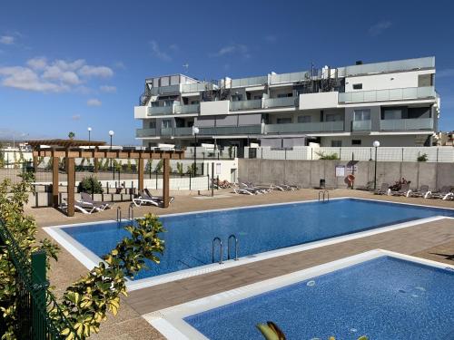 une piscine devant un grand bâtiment dans l'établissement Apartamento Nuevo Terrazas, à Granadilla de Abona
