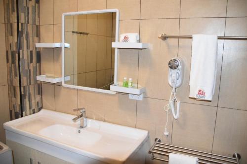 a bathroom with a sink and a mirror at Al - Minhaj Service Apartments in Nadi