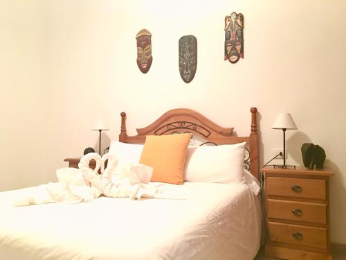 a bedroom with a white bed with stuffed animals on it at Samsara Home in Caleta de Sebo