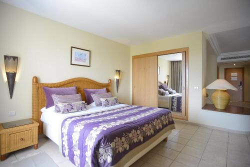 a bedroom with a large bed with purple pillows at Djerba Resort- Families and Couples Only in Houmt Souk