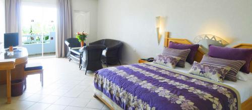 a bedroom with a bed and a desk and a computer at Djerba Resort- Families and Couples Only in Houmt Souk