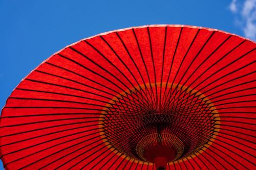 um guarda-chuva vermelho com um céu azul ao fundo em Kougetsu Sanso -- Moon Villa in Tokyo em Hachioji