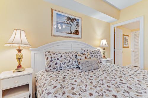 een slaapkamer met een wit bed en 2 lampen bij Sterling Shores in Destin