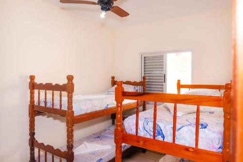 - une chambre avec 2 lits superposés et un ventilateur de plafond dans l'établissement Apartamento Praia Grande Ubatuba 2 vagas garagem Internet WiFi, à Ubatuba