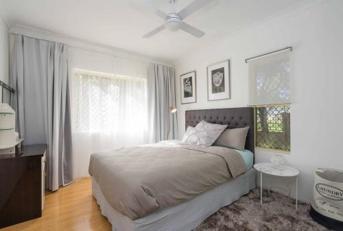 una camera con letto e ventilatore a soffitto di Urban Escape – Strathfield a Sydney