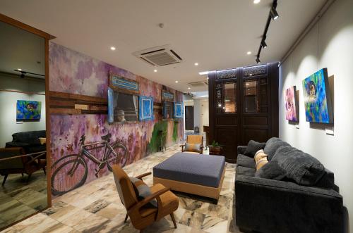 a living room with a couch and a bike mural at Macalister Terraces Hotel in George Town
