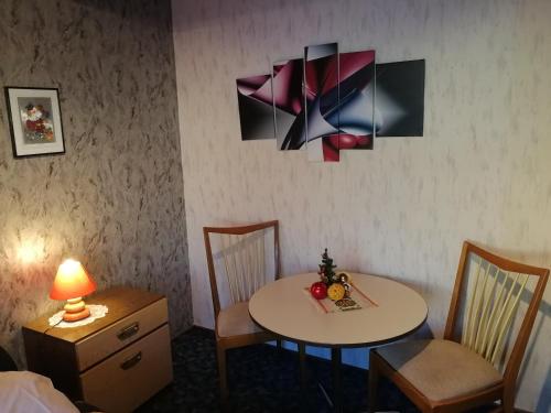 a room with a table and chairs and a lamp at Gasthaus Hochwald in Hattgenstein