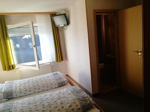 a small bedroom with a bed and a window at Gasthaus Hochwald in Hattgenstein