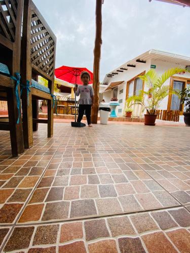 a young child holding an umbrella on a patio at Zurisadai in Puerto Ayora