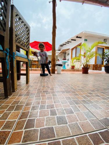 a young boy standing on a tile floor in a patio at Zurisadai in Puerto Ayora