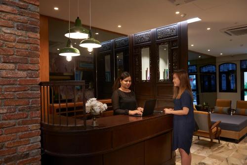 two women standing at a counter in a salon at Macalister Terraces Hotel in George Town
