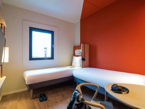 a small room with two beds and a window at ibis budget Stein Maastricht in Stein