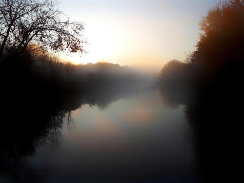 a misty river with the sun rising in the background at Paddler's Lane Retreat in Confluence
