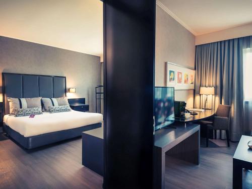 ein Hotelzimmer mit einem Bett und einem Schreibtisch in der Unterkunft Mercure Santiago Centro in Santiago