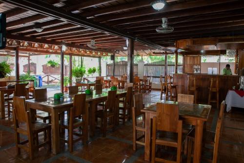 卡普兰干HOTEL BAHÍA PINORROA的一间空荡荡的餐厅，摆放着木桌椅