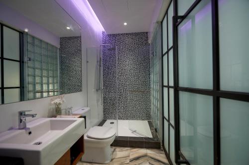 a bathroom with a toilet and a sink and a shower at Macalister Terraces Hotel in George Town