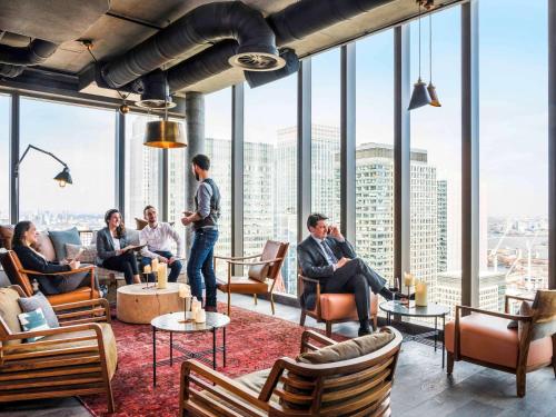 a group of people sitting in a room with windows at Novotel London Canary Wharf in London