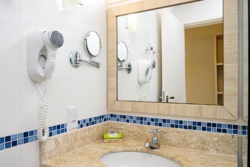 a bathroom with a sink and a mirror at Pousada Don Diego in Ubatuba
