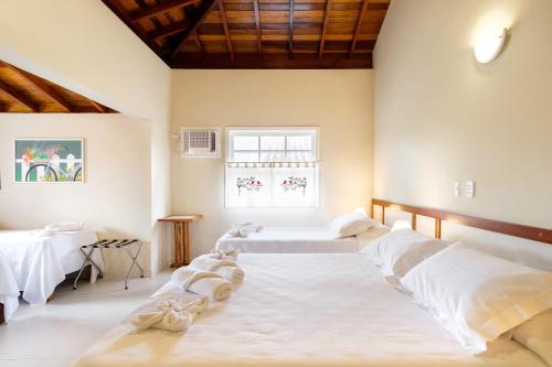 a bedroom with two beds and a window at Pousada Don Diego in Ubatuba