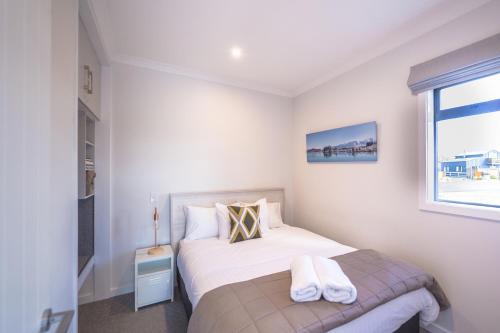 a small bedroom with a bed and a window at Twizel Cottages in Twizel