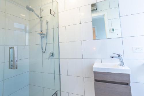 W łazience znajduje się prysznic i umywalka. w obiekcie Twizel Cottages w mieście Twizel