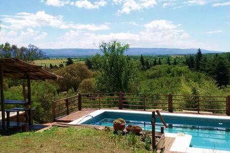 a swimming pool with a view of the countryside at Casas Pura Vida in Villa General Belgrano