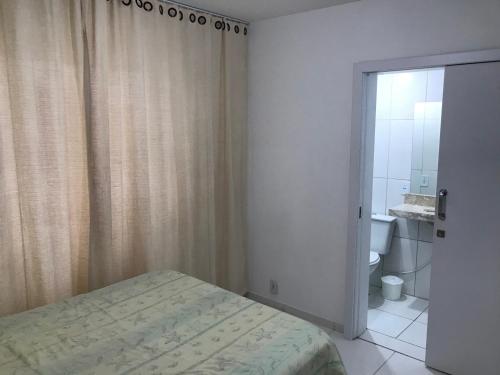 ein Schlafzimmer mit einem Bett und ein Badezimmer mit einem WC in der Unterkunft Ótimo Apto 2 quartos, Av. Brasil, de frente, quadra mar. in Balneário Camboriú