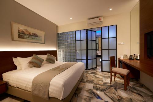 Macalister Terraces Hotel في جورج تاون: غرفة نوم بسرير ومكتب في غرفة