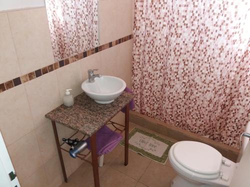 y baño con lavabo y aseo. en Aitue Bungalows en Gualeguaychú