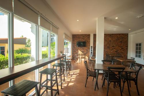 a restaurant with tables and chairs and windows at Sino Mansion in Ranong