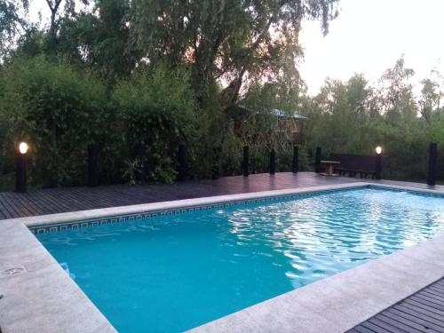 a swimming pool with blue water in a yard at Cabañas Sidharta in Tigre