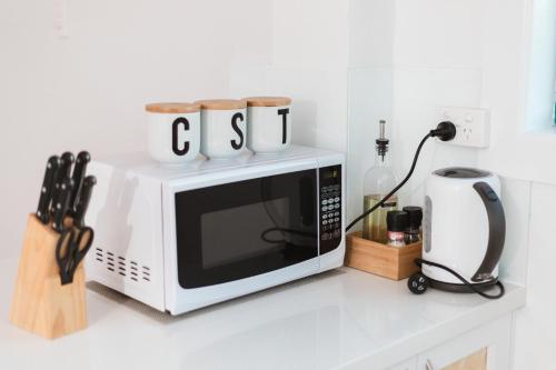 a microwave sitting on top of a kitchen counter at White Waves on the Beach in Hastings Point