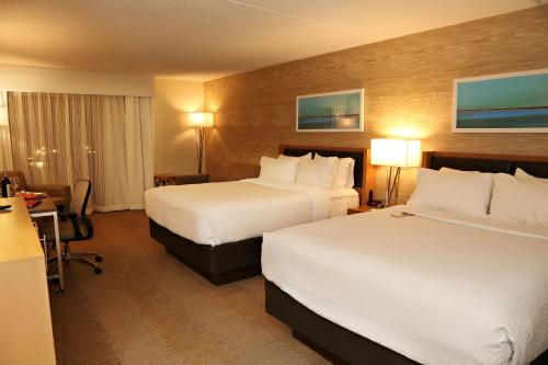 a hotel room with two beds and a desk at enVision Hotel & Conference Center Mansfield-Foxboro in Mansfield