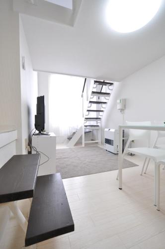 a white living room with a black bench and stairs at Easy Access to downtown area, Sapporo Dome AMS503 in Sapporo