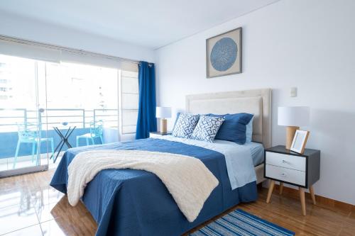 um quarto com uma cama azul e uma grande janela em GLOBALSTAY Lux Apt Great Location GameRoom em Lima