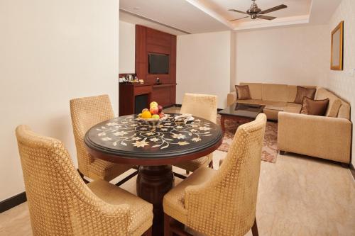 a living room with a table and chairs and a couch at LP Vilas in Dehradun