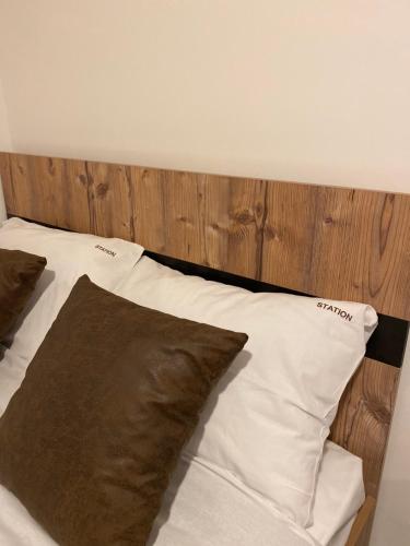 Una cama con almohadas marrones y blancas. en Studio Apartment Station Kopaonik,Milmari Resort, en Kopaonik