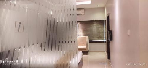 a glass door to a bathroom with a bed in a room at The Curzon Court in Bengaluru