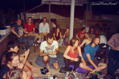 Un groupe de personnes assises dans une foule dans l'établissement Second Home Hostel, à Istanbul