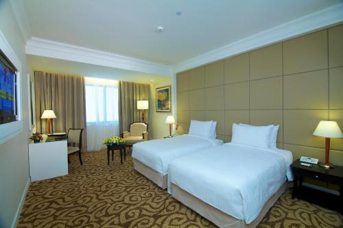 a hotel room with a large bed and a desk at Perdana Kota Bharu in Kota Bharu
