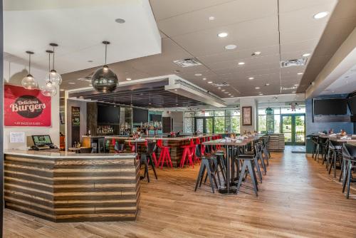 a restaurant with tables and chairs and a bar at Holiday Inn Hotel & Suites - Joliet Southwest by IHG in Joliet