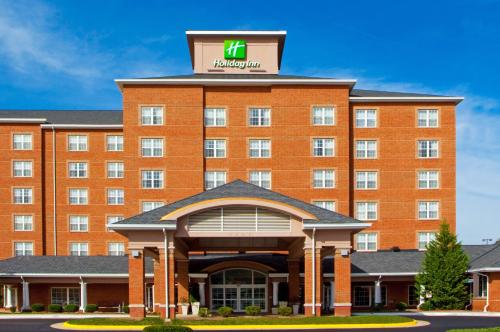 a large red brick hotel with a sign on top at Holiday Inn Chantilly-Dulles Expo Airport by IHG in Chantilly