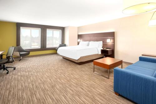 a hotel room with a bed and a couch at Holiday Inn Express Hotel & Suites Marysville by IHG in Marysville