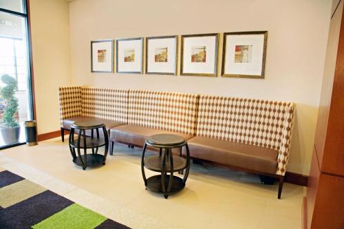 a waiting room with two benches and two tables at Staybridge Suites Chantilly Dulles Airport by IHG in Chantilly